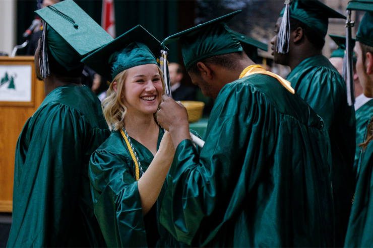 Two students celebrating graduation at graduation ceremony